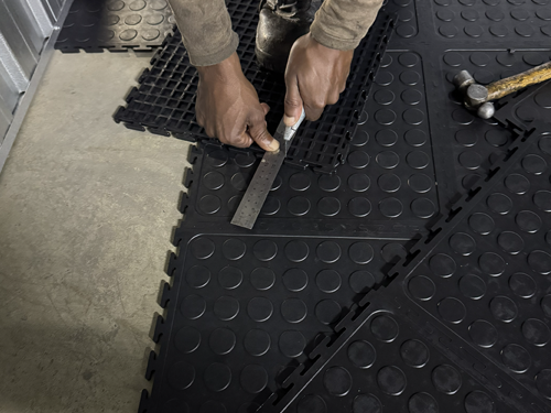 Dura Tile PVC interlocking floor tile being measured and cut to fit