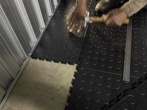 Cut Dura Tile PVC interlocking floor tiles being fitted into a floor gap