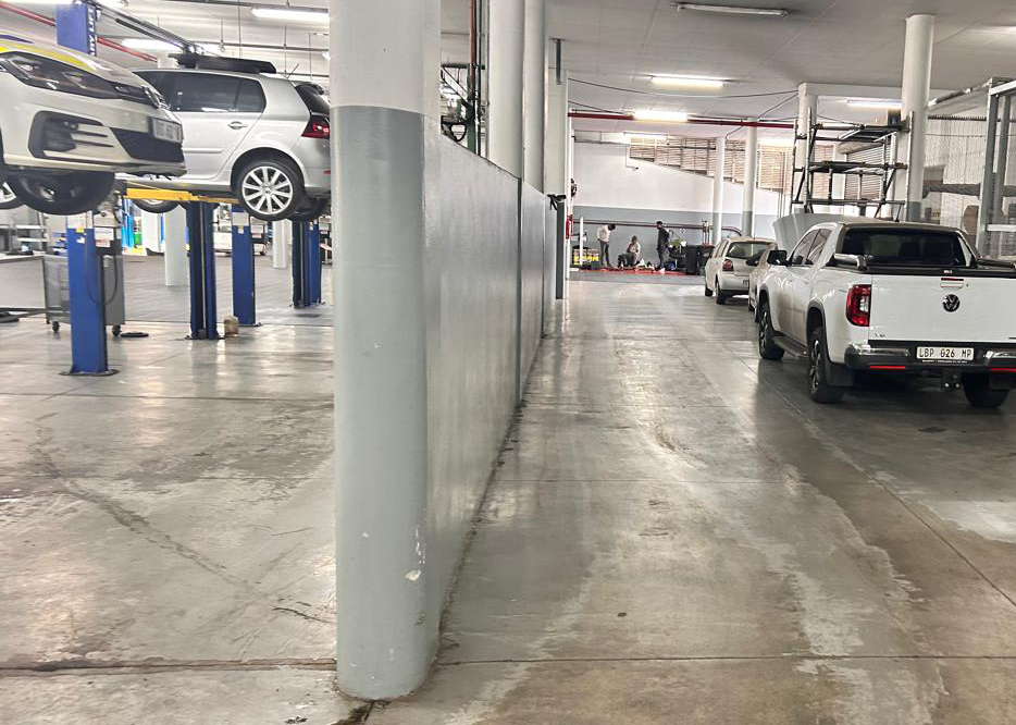 Commercial vehicle workshop with ageing concrete floor before PVC tile installation