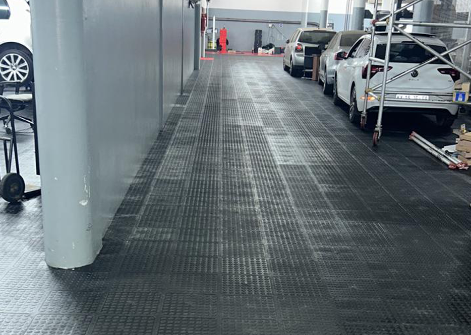 Black Dura Tile flooring installed in a busy commercial vehicle workshop