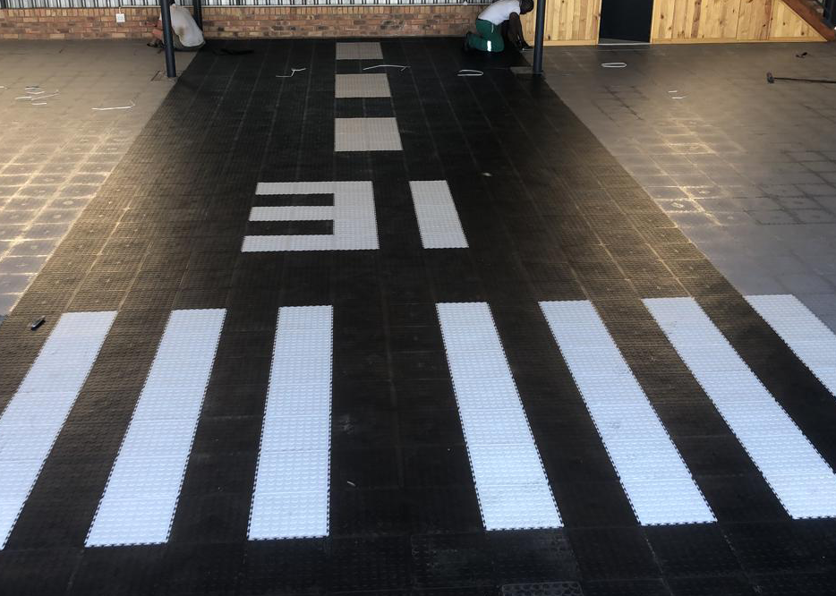 Black, white and grey Dura Tile flooring installed in a boat and aircraft hangar