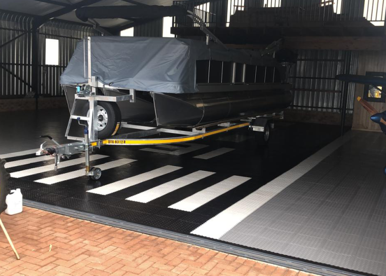 Boat on a trailer inside a hangar with black, grey and white Dura Tile flooring
