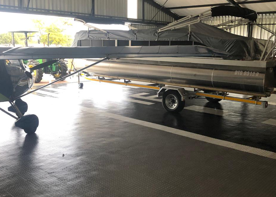 Completed Dura Tile flooring in a private hangar used for a boat and small aircraft