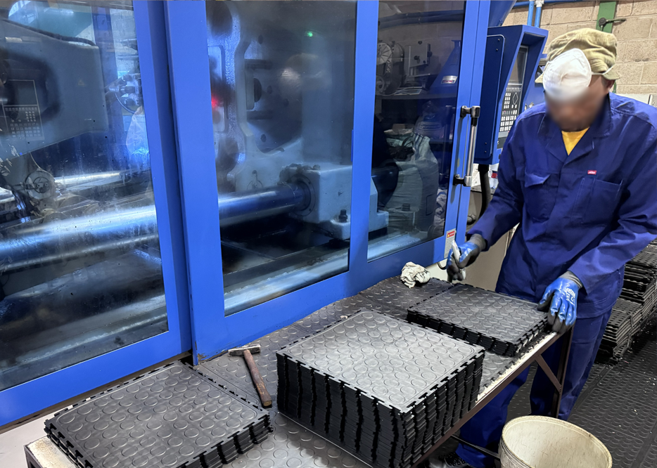 Durable Floors employee inspecting PVC tiles during manufacturing